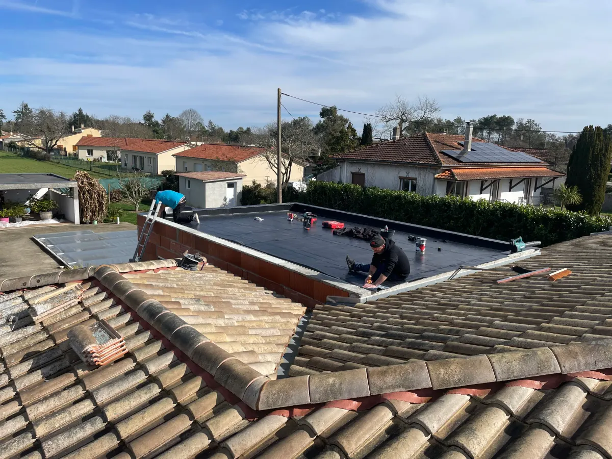 Pose d'une membrane d'étanchéité sur toit plat, équipe au travail